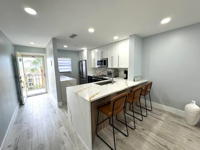 a kitchen with stainless steel appliances a stove sink microwave and refrigerator