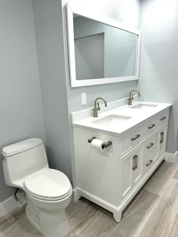 a bathroom with a sink a toilet and mirror