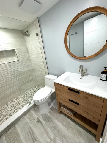 a view of a roof deck with table and chairs under an umbrella with wooden floor