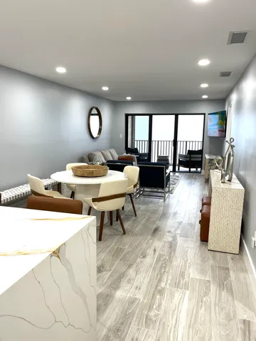 a kitchen with stainless steel appliances kitchen island granite countertop a refrigerator a sink a stove a microwave and wooden cabinets