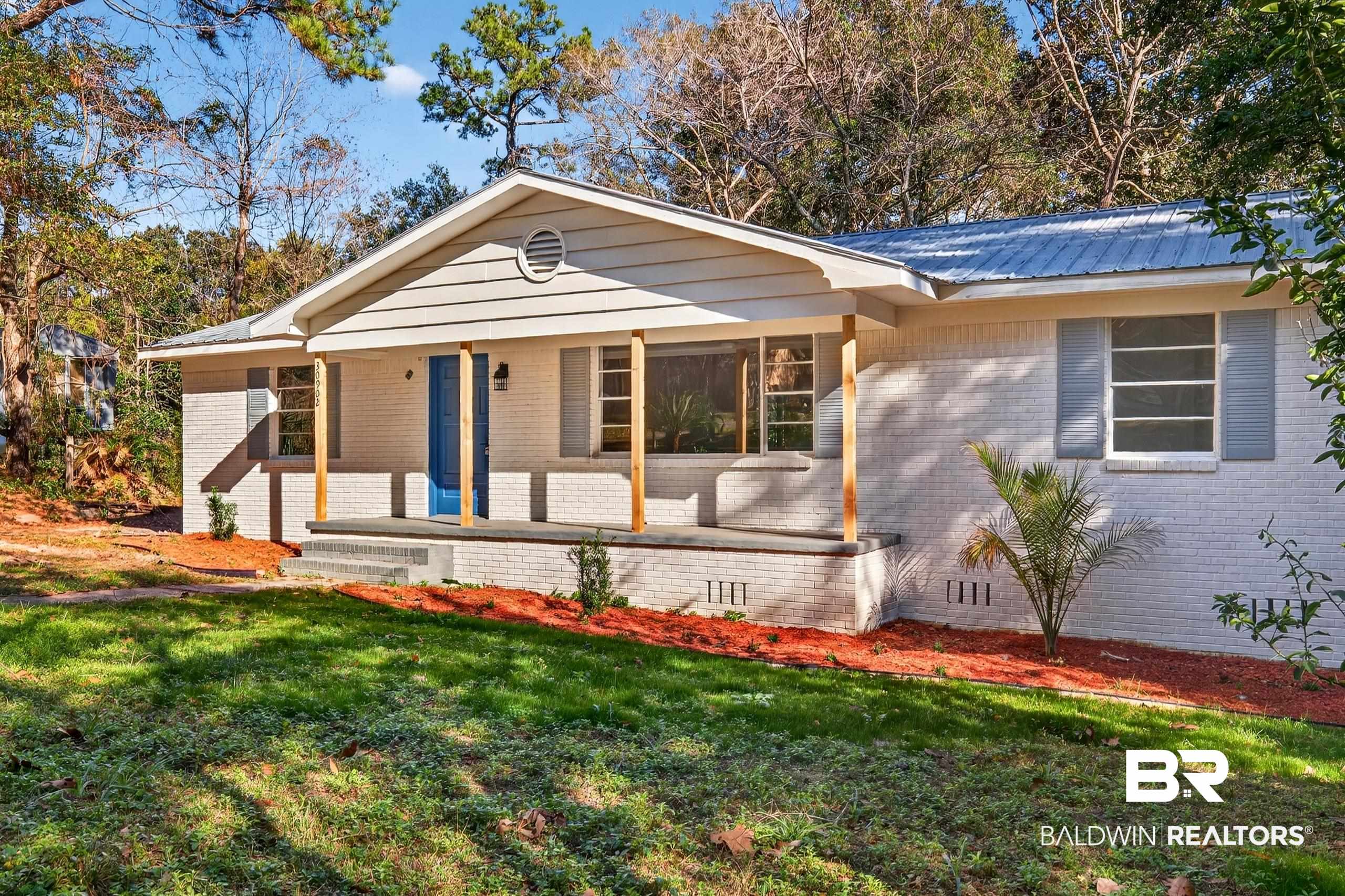 30902 Stanton Road Spanish Fort, AL 36527 - Photo 2 of 27 View of front of property with a porch, brick siding, a metal roof, a front lawn, and crawl space