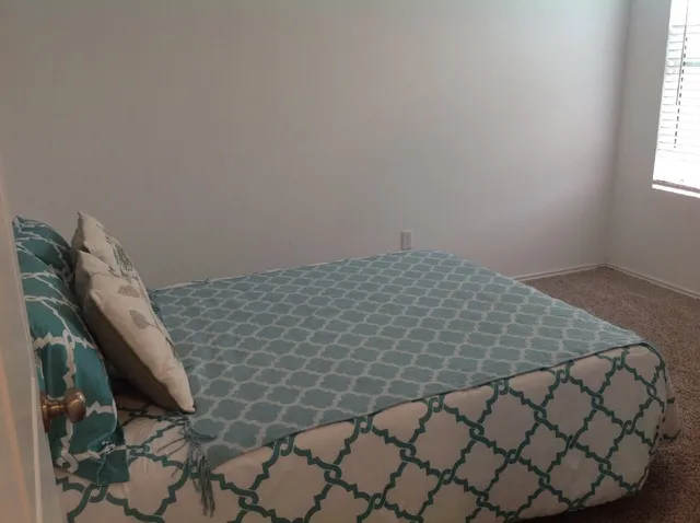 a bedroom with a bed and window