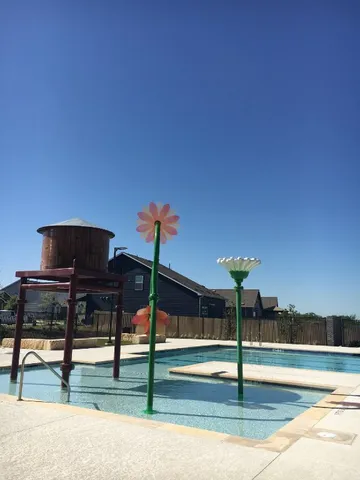 a view of swimming pool with outdoor seating and yard in back