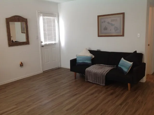 a living room with furniture and a wooden floor