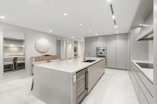 a large kitchen with kitchen island a large counter space a sink stainless steel appliances and cabinets