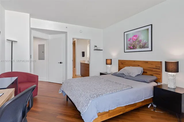 a bedroom with a bed and a painting on the wall