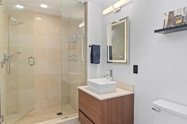 a bathroom with a sink mirror and shower