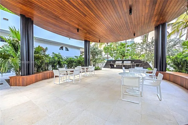 a view of patio with couches and chairs under an umbrella