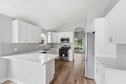 a kitchen with a sink a counter top space stainless steel appliances and cabinets