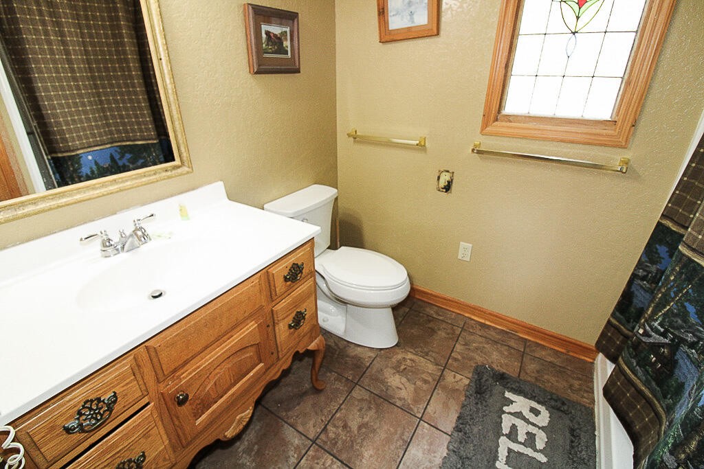 443 Loop Road Gatlinburg, TN 37738 - Photo 12 of 40 a bathroom with a sink a toilet and a window