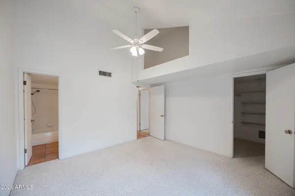 a view of a big room with closet and a ceiling fan