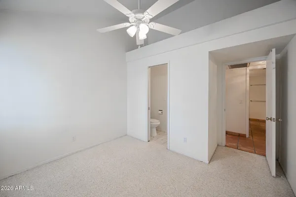 an empty room with a ceiling fan and a bathroom