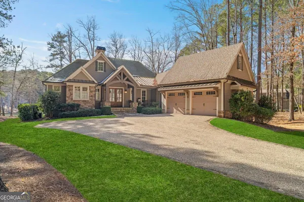 a front view of a house with a garden and trees