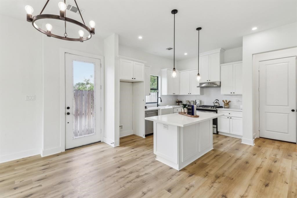 311 Tennessee Street Houston, TX 77029 - Photo 4 of 15 a kitchen with stainless steel appliances granite countertop a white cabinets and a chandelier