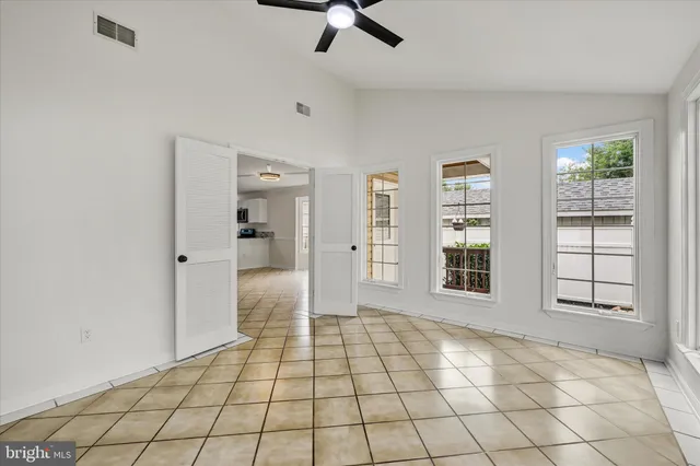 a view of an empty room with window and cabinet area