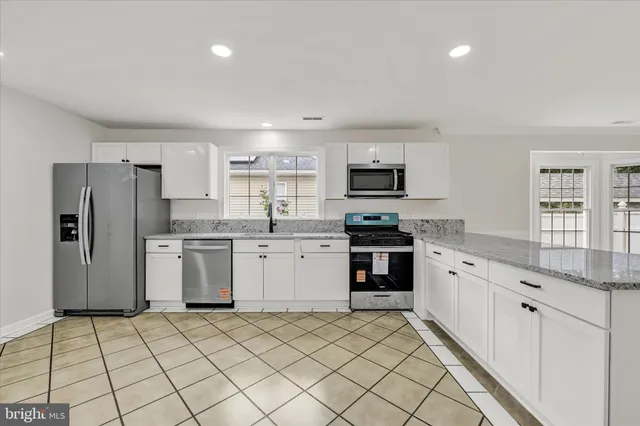 a kitchen with a sink a counter top space stainless steel appliances and cabinets