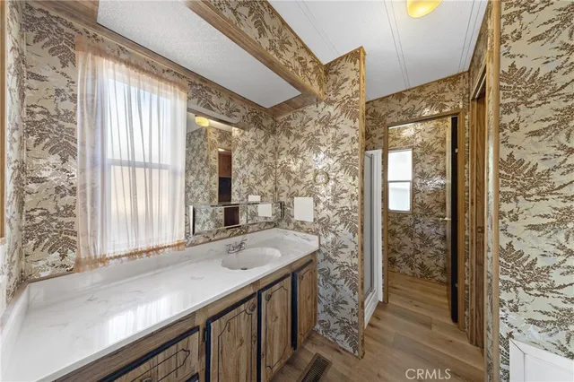 a bathroom with a granite countertop sink and a large mirror