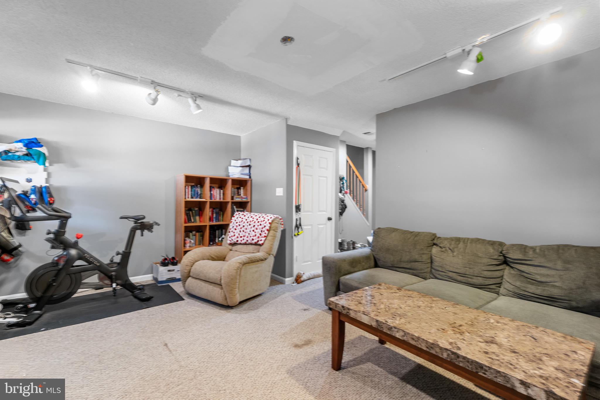 14010 Valleyfield Drive Silver Spring, MD 20906 - Photo 19 of 24 a living room with furniture and a gym machine with rug