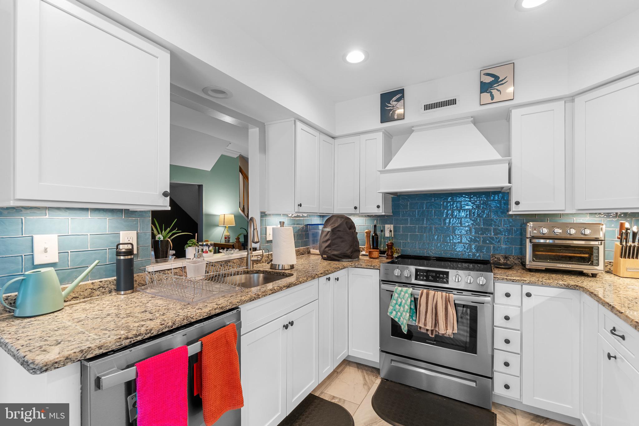 14010 Valleyfield Drive Silver Spring, MD 20906 - Photo 3 of 24 a kitchen with granite countertop a sink stainless steel appliances and white cabinets