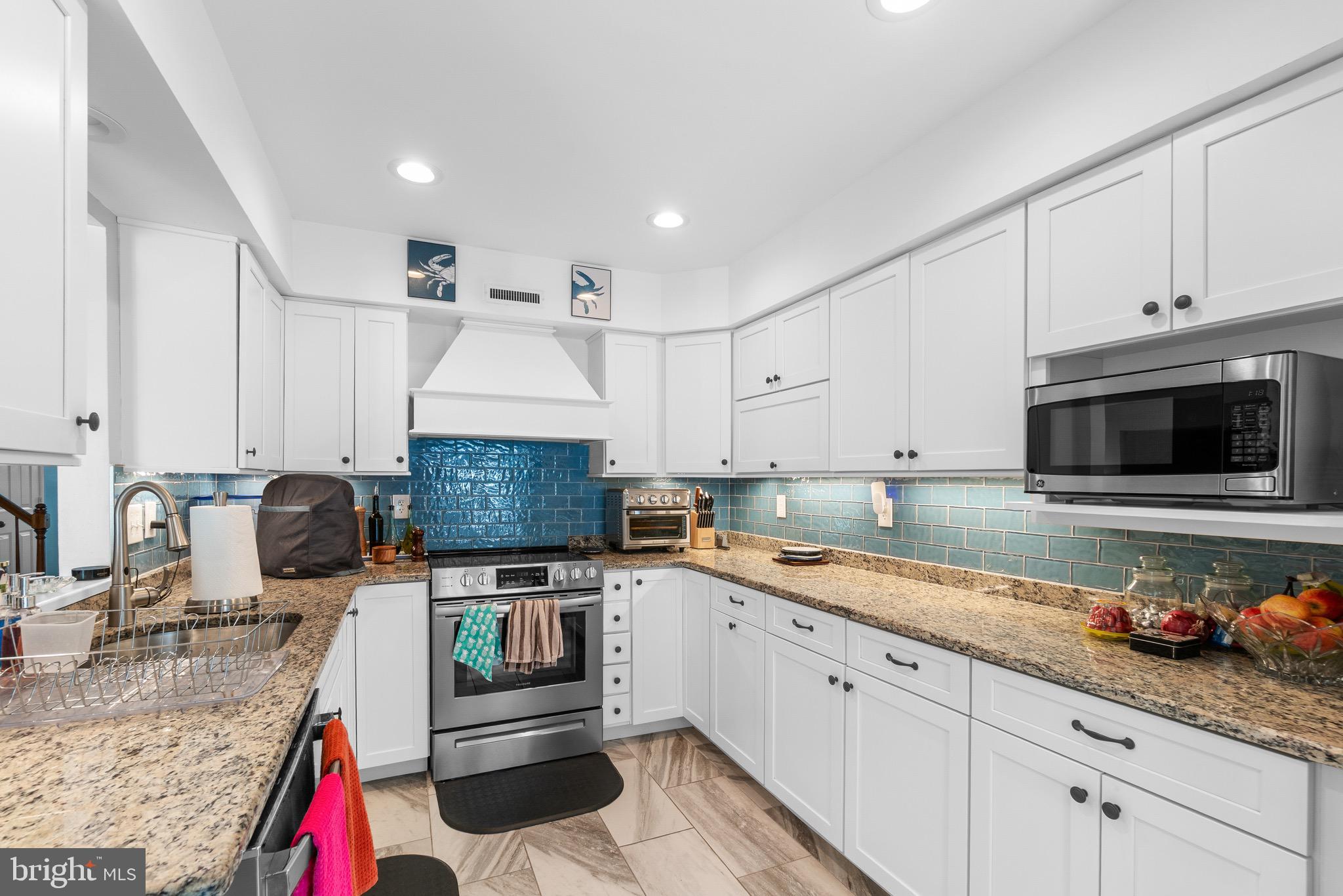 14010 Valleyfield Drive Silver Spring, MD 20906 - Photo 6 of 24 a kitchen with granite countertop a sink stainless steel appliances and cabinets