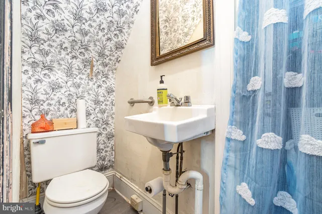a bathroom with a toilet sink and mirror