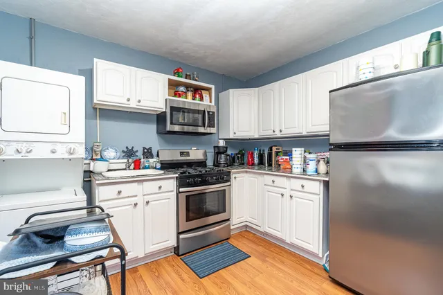 a kitchen with granite countertop a sink cabinets and stainless steel appliances