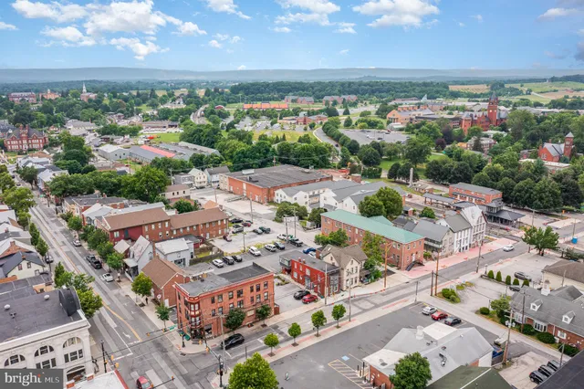 an aerial view of a city with lots of residential buildings ocean and mountain view in back