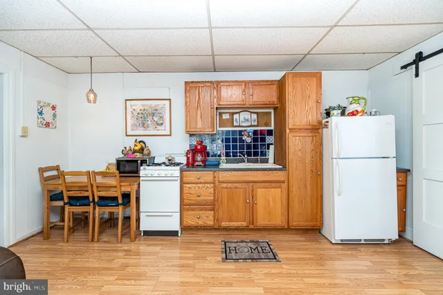 a kitchen with furniture a refrigerator and a stove top oven