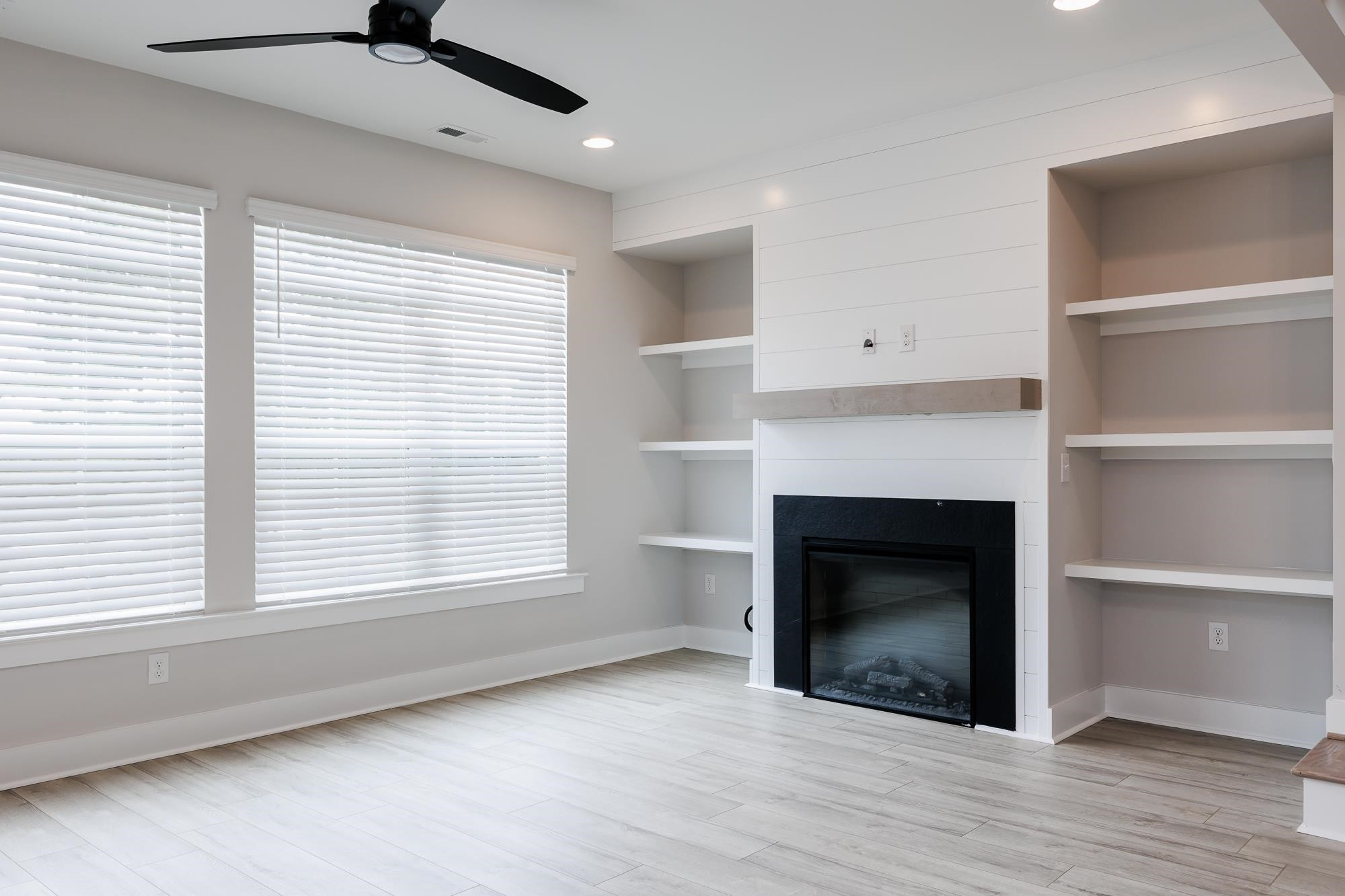 8236 Ebenezer Church Road Raleigh, NC 27613 - Photo 4 of 17 an empty room with a fireplace and windows
