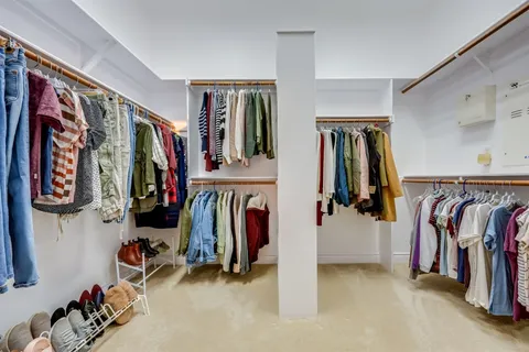 a view of walk in closet with clothes