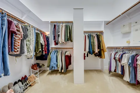a view of walk in closet with clothes
