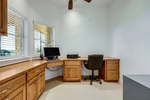 a view of a workspace with furniture and a window