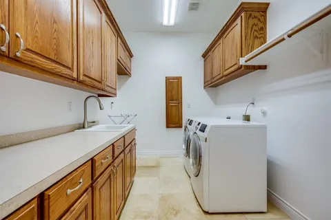 a utility room with stainless steel appliances washer and dryer