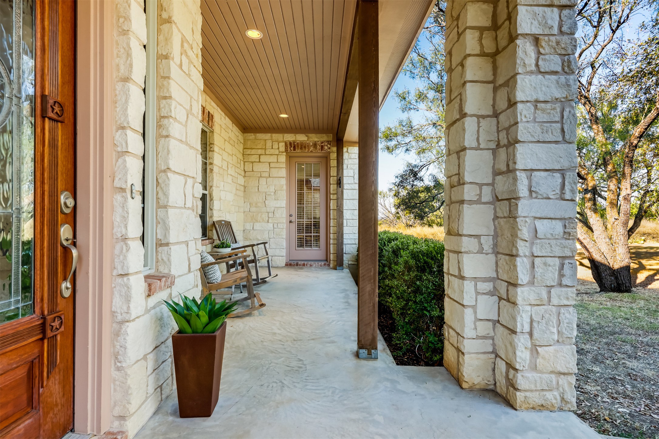 104 Running Brook Trail Spicewood, TX 78669 - Photo 5 of 40 a building with potted plants in front of door