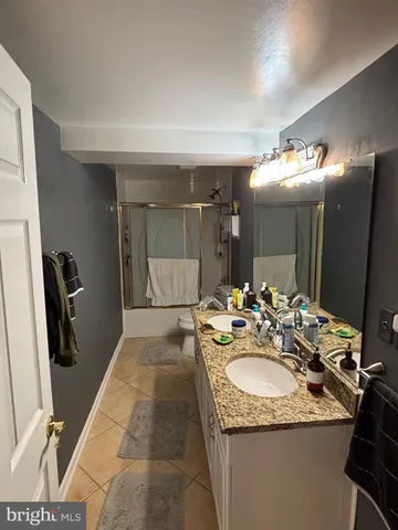 a bathroom with a sink double vanity granite and a mirror
