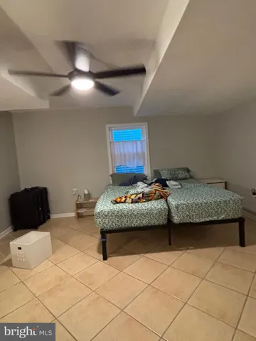 a bedroom with a bed and a lamp on the dresser