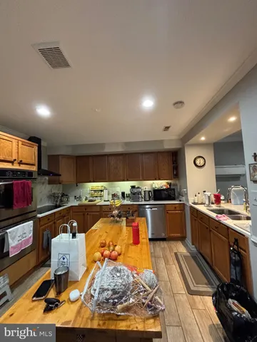 a kitchen with stainless steel appliances granite countertop a stove top oven and cabinets