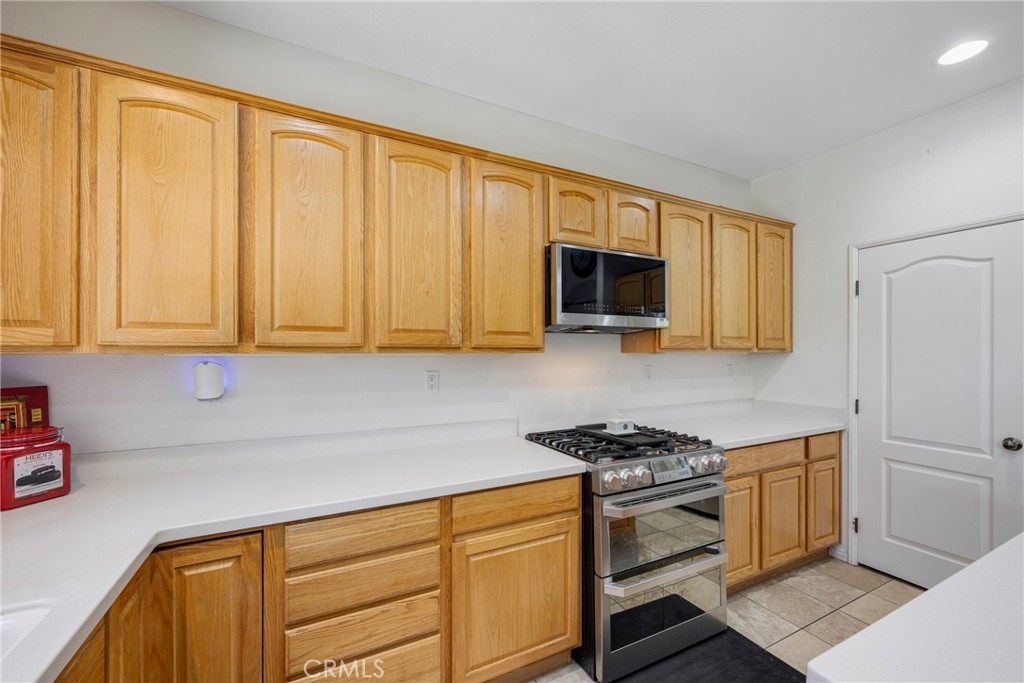 3819 St Austell Way Perris, CA 92571 - Photo 14 of 64 a kitchen with stainless steel appliances granite countertop a stove a sink and a microwave