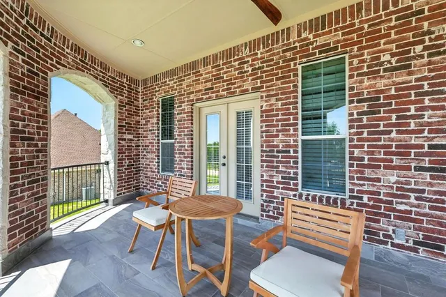 a front view of a house with a chairs and table in a patio