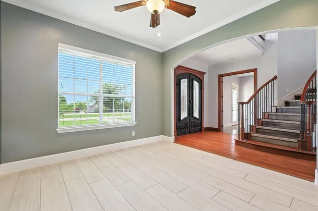 a view of a room with a ceiling fan and hardwood floor