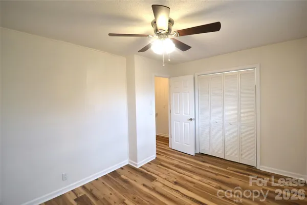 a view of a room with wooden floor and a ceiling fan