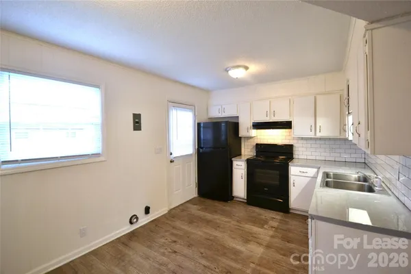 a kitchen with granite countertop a refrigerator and a stove top oven