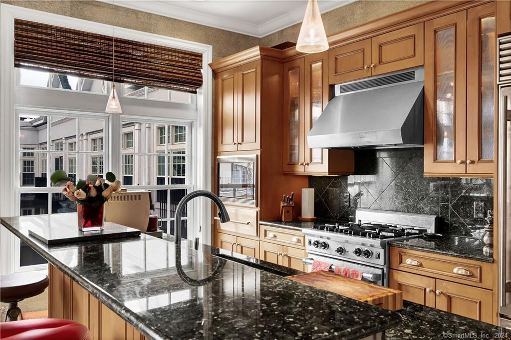 a kitchen with stainless steel appliances granite countertop a sink dishwasher stove and refrigerator