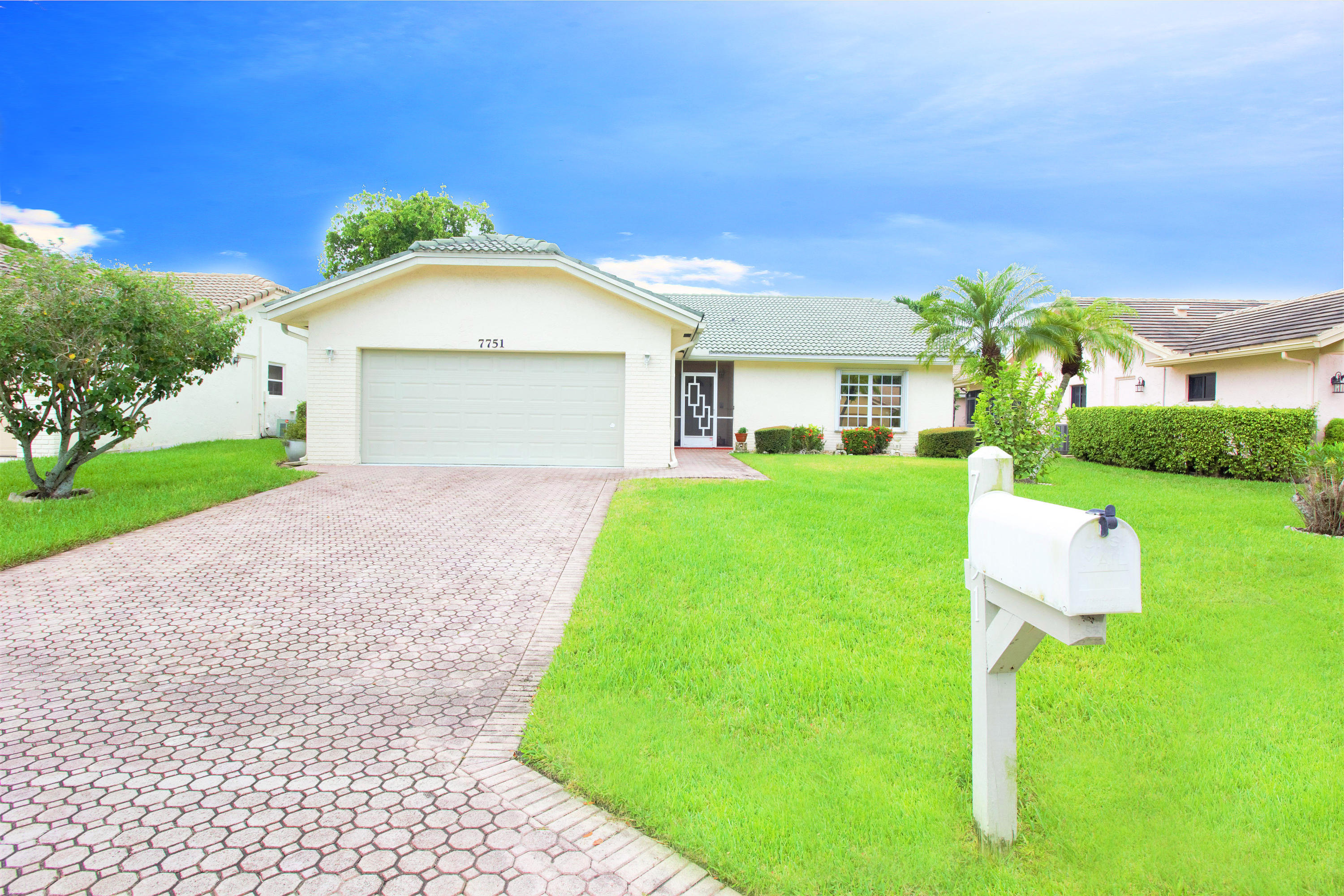 7751 Cloverfield Circle Boca Raton, FL 33433 - Photo 1 of 26 a front view of a house with a yard and garage