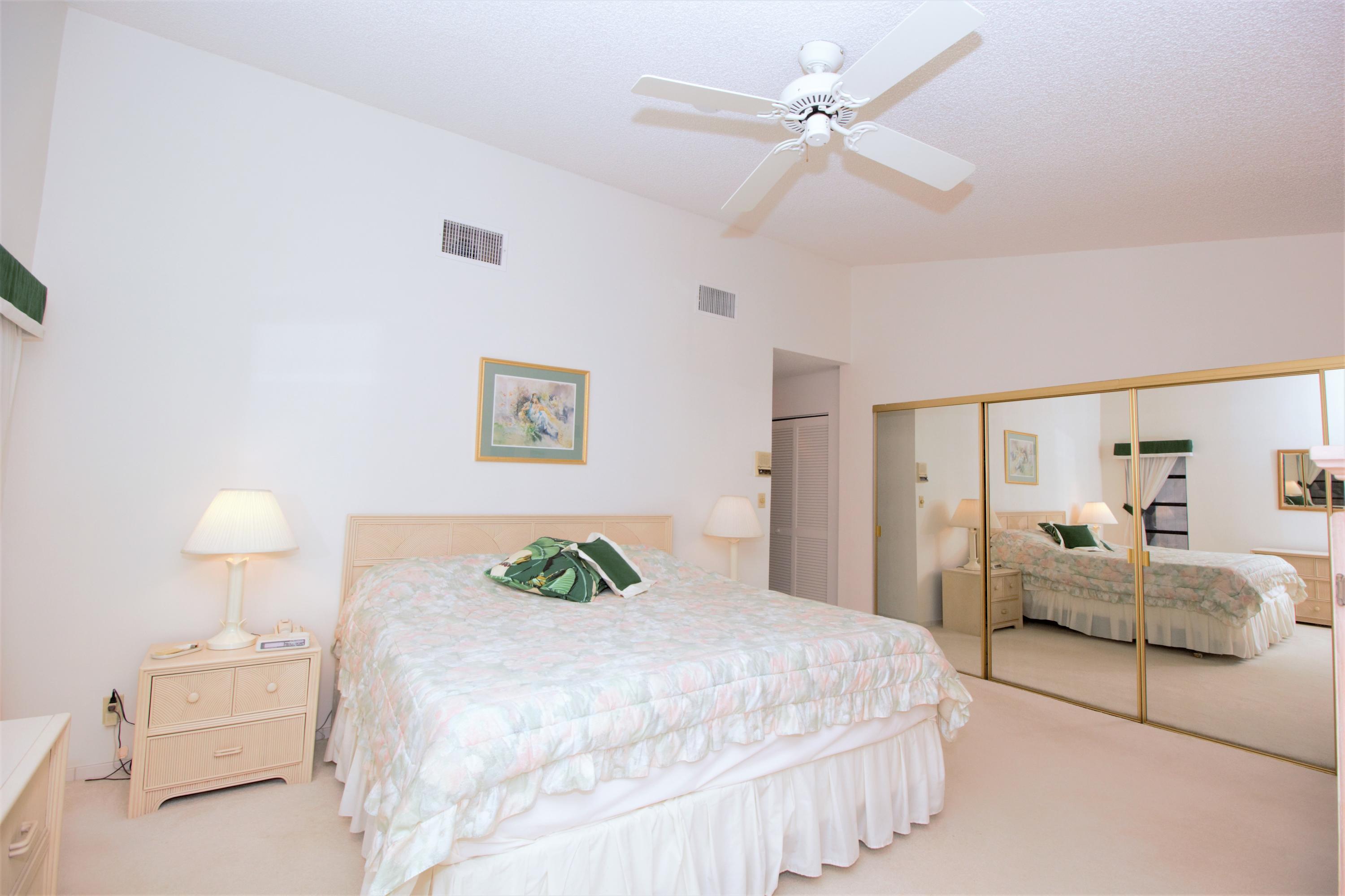 7751 Cloverfield Circle Boca Raton, FL 33433 - Photo 13 of 26 a bedroom with a bed and a chandelier