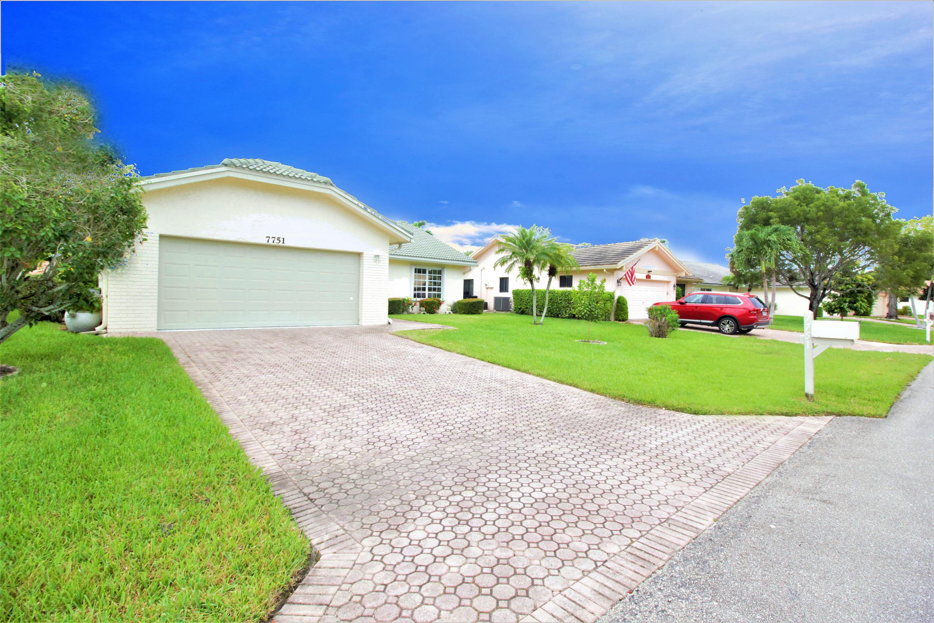 7751 Cloverfield Circle Boca Raton, FL 33433 - Photo 2 of 26 a view of a house with a yard and garage