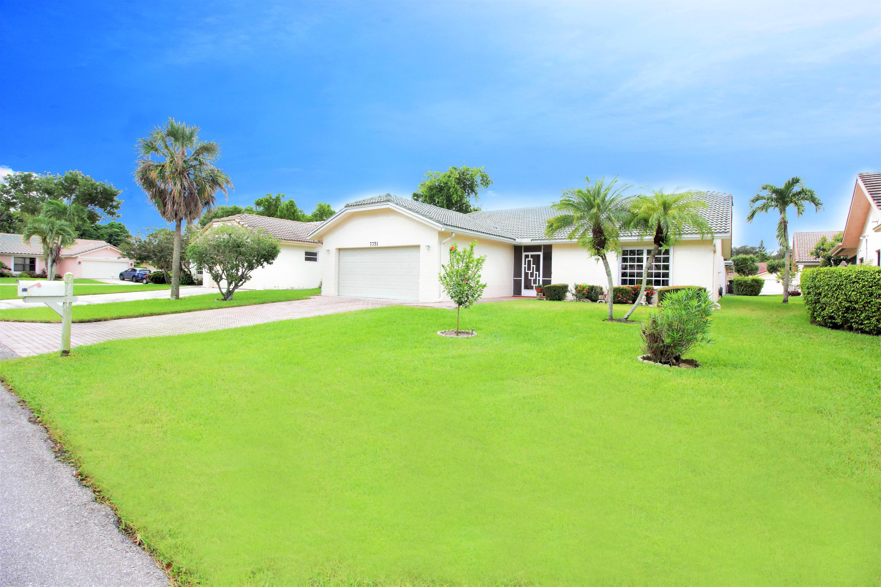 7751 Cloverfield Circle Boca Raton, FL 33433 - Photo 3 of 26 a view of a white house with a big yard and potted plants