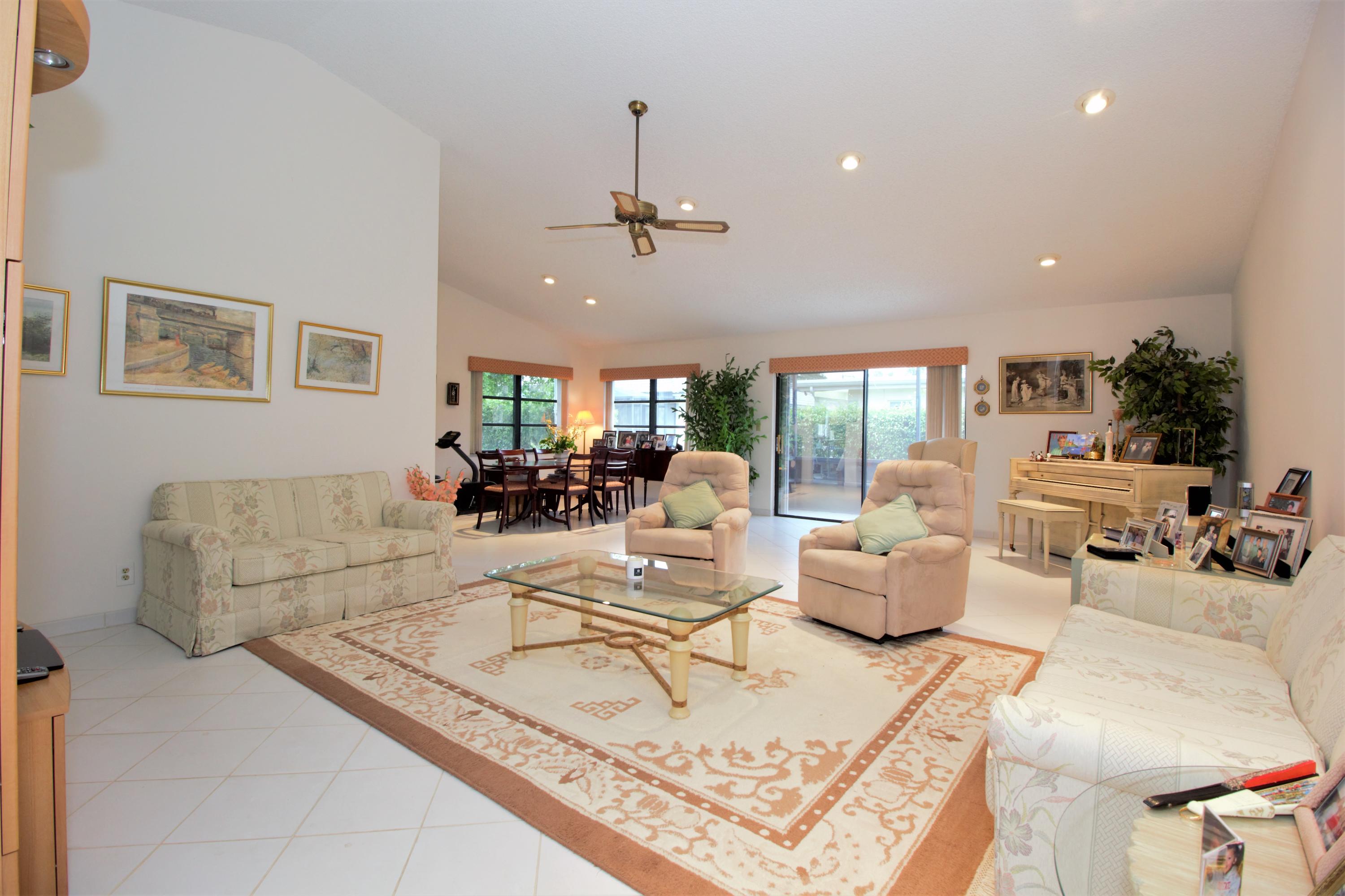 7751 Cloverfield Circle Boca Raton, FL 33433 - Photo 7 of 26 a living room with furniture a chandelier and a rug