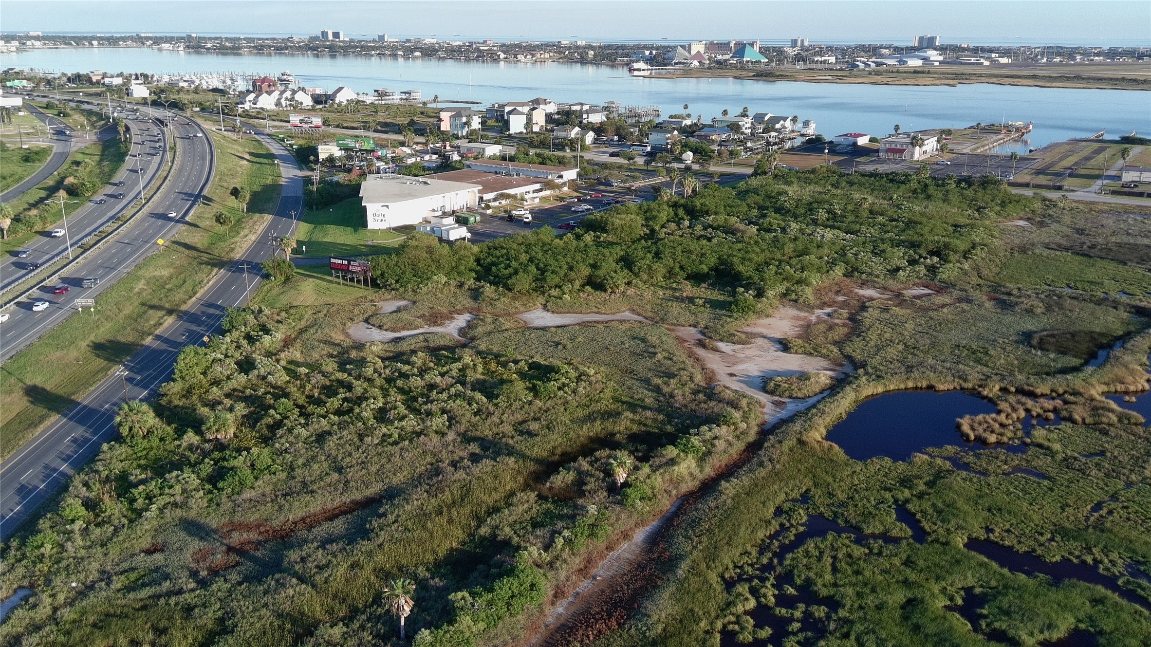 8509 Teichman Road Galveston, TX 77554 - Photo 3 of 16 an aerial view of a city with lots of residential buildings ocean and mountain view in back