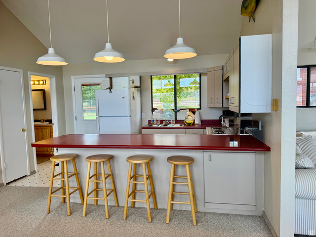 1825 North Cisco Road Laketown, UT 84038 - Photo 15 of 34 Kitchen featuring a red countertop, white cabinetry, a built-in sink, and pendant lighting